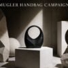 Mugler Handbag Campaign featuring a sculptural black handbag displayed on a stone pedestal with dramatic lighting and architectural forms that emphasize its artistic design.